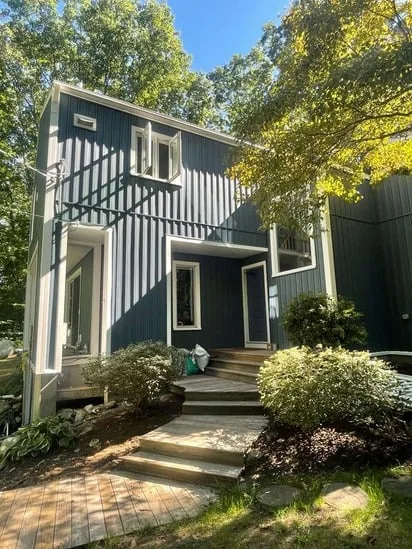 Front entrance and windows framed by the newly installed batten siding Medway MA.