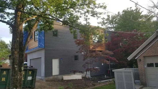 Completed sections of the garage and upper levels of a metal siding installation Newton MA.