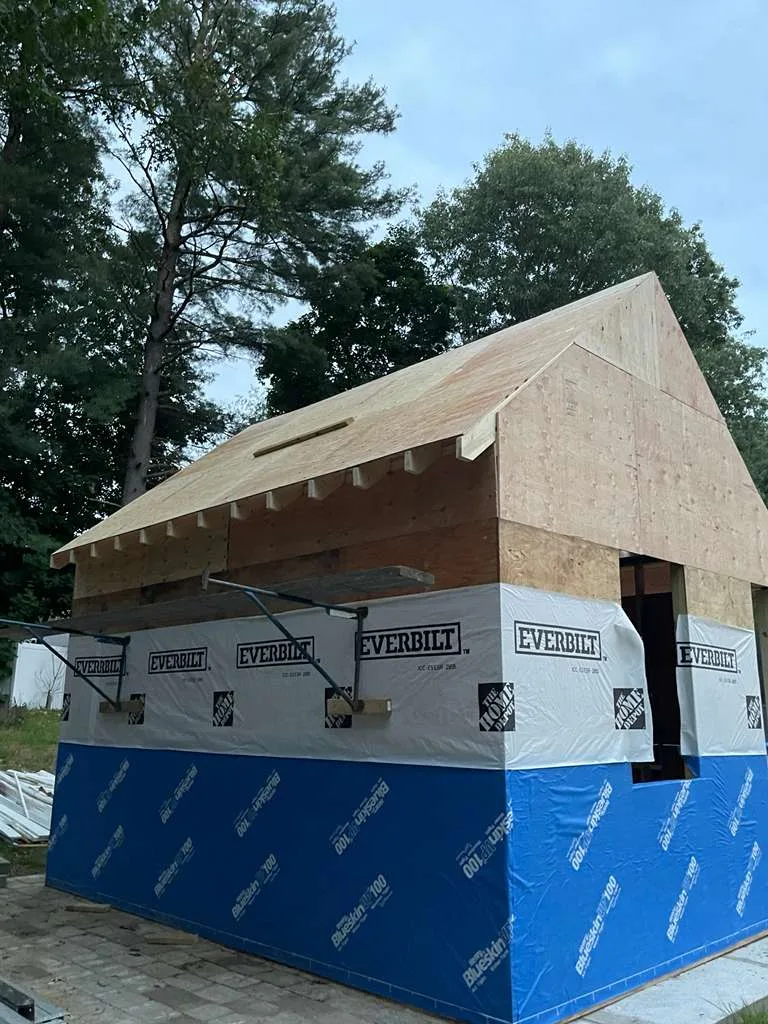 Side view showing plywood roof sheathing on the 10x16 storage shed construction.